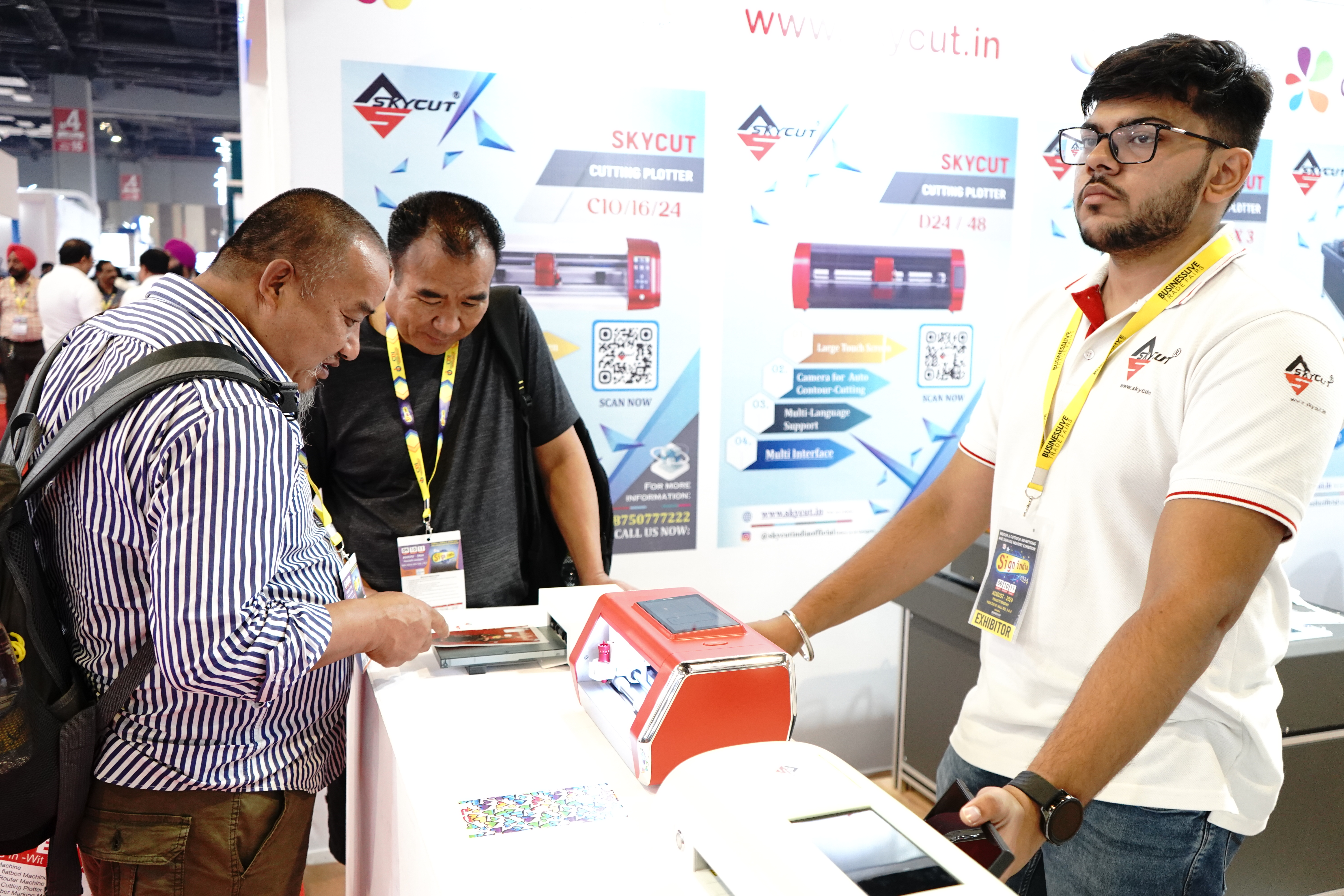 The team explaining a Skycut cutter at the booth.